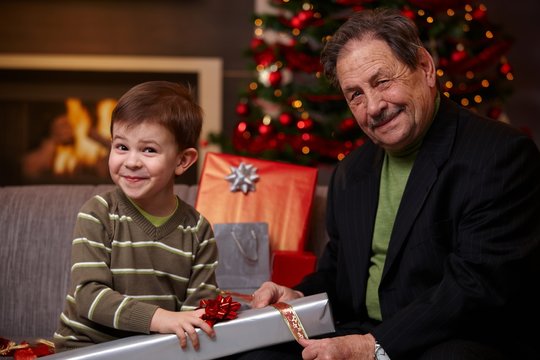 Grandfather and grandson wrapping gifts together