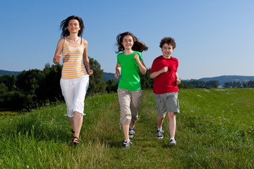 Active family - mother and kids running outdoor