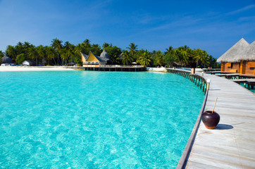 Maldives. A path over ocean from water houses to coast