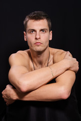 Fototapeta premium Portrait of a young man sitting on a chair