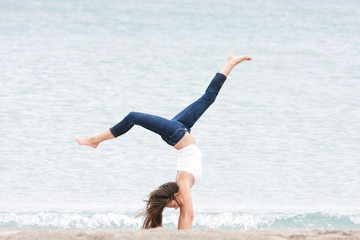 young girl doing gymnastics on sea background