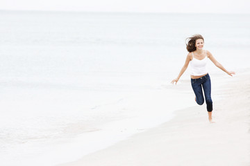 young happy girl running on beach