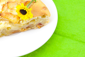 piece of apple pie and a flower lying on the green cloth
