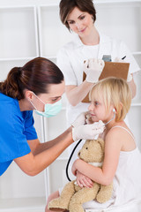 pediatrician giving little girl checkup in hospital