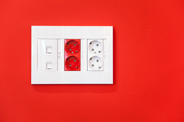 Electric and network sockets in a red wall