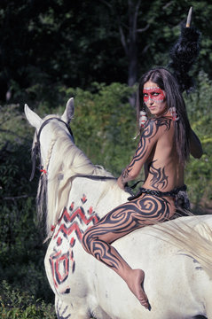 indian girl sits astride a horse