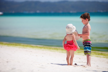 Two adorable kids standing by ocean shore