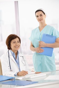 Portrait of senior medical doctor with assistant