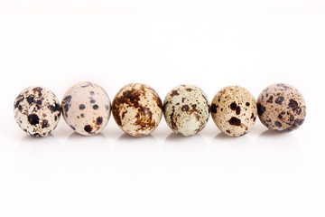Obraz premium Six different quail eggs in the raw isolated on white