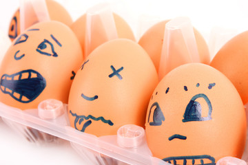 Group of brown hen's eggs with different faces in the box