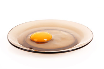 Cracked hen's egg in the glass plate isolated on white