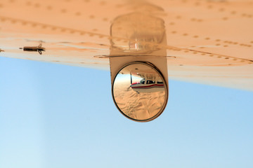 Reflet dans le rétroviseur d'un avion de tourisme