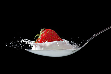 Strawberry splashing into milk