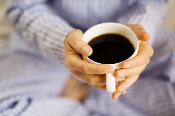 Female hands holding a cup of coffee.