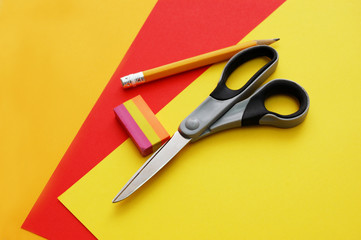closeup of colourful papers, scissors, pencil and eraser