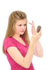 young girl looks through  handglass