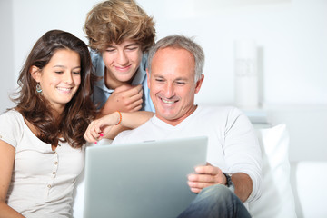Fototapeta na wymiar Family at home with laptop computer