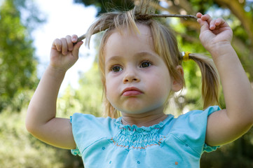The naughty little girl plays with a branch