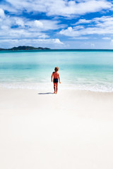 Child walking on a tropical beach; Seychelles