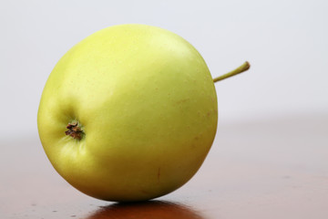 Green organic apple on a table. Shallow dof