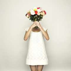 Woman holding roses in front of head