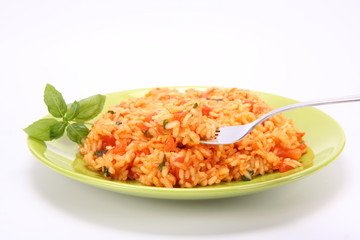 Risotto with tomatoes with basil being eaten with a fork