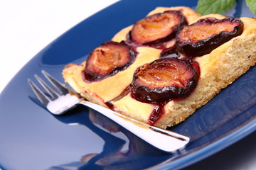Piece of Plum Pie on a blue plate decorated with a mint twig