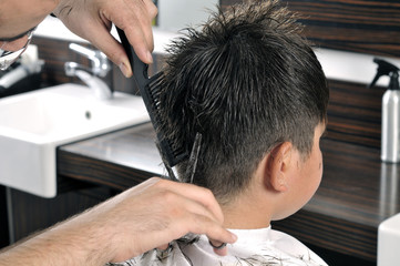 Barber cutting hair with scissor © uwimages