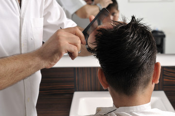 Barber cutting hair with scissor