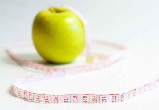 green apple and measure tape, dieting theme