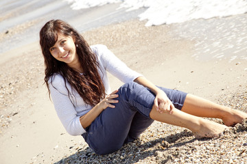 Fototapeta na wymiar Pretty young woman with sitting on beach