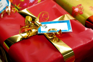 Red Christmas present with gold ribbon and tag