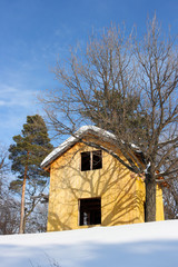 Wooden cottage against a blue sky in the winter