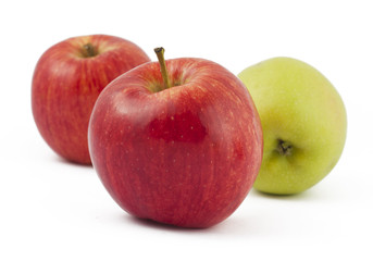 Two red and one green apples on white