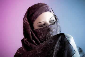 Arab veiled woman dressed lit with two lights, pink and blue