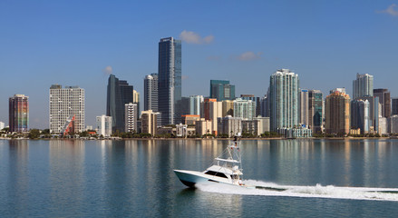 Fototapeta na wymiar Miami Skyline with fishing yacht cruising by