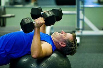Fototapeta na wymiar Man Lifting weights in Gym