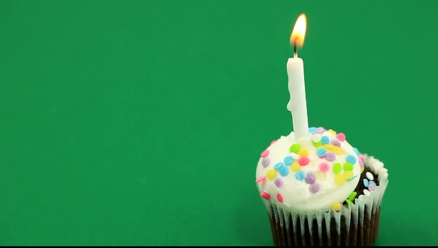 Single birthday cupcake over green