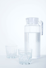 Pitcher and glass with ice cubes of mineral water