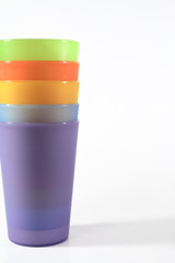 Plastic glass of various color on white background