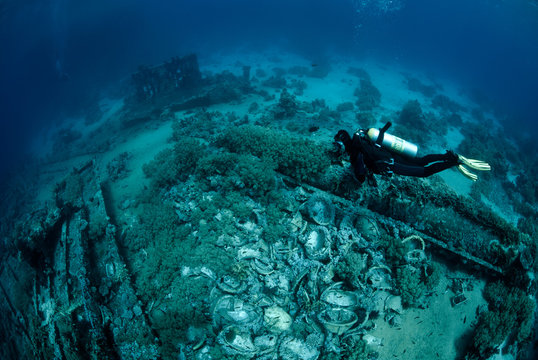 Female scuba diver over ship wreckage. Yolanda Reef, Red Sea