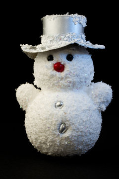 Schneeman vor schwarzem Hintergrund