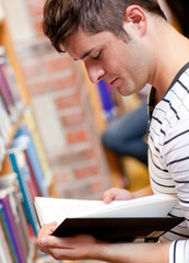 Serious young man reading a book