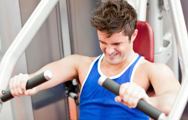 Strong athletic man using a bench press