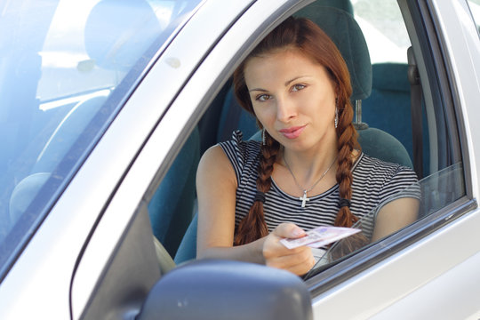 Beautiful woman show her driver's  licence in car