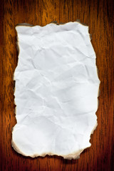 white crumple & burn paper on mahogany wood texture