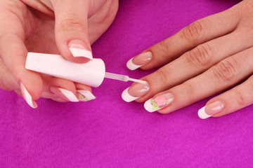 Beautiful woman hands with french manicure on pink background