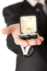 Man in suit holding engagement ring on white isolated background