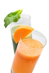fresh juices from carrot and parsley in glasses isolated
