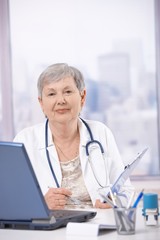 Senior doctor working at desk